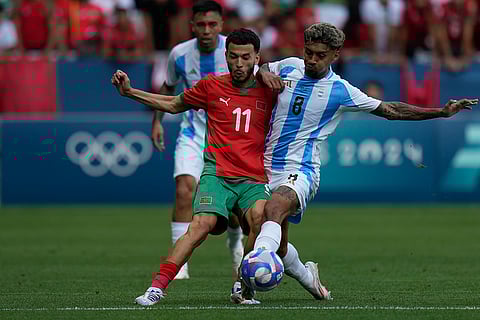 Zakaria El Ouahdi and Cristian Medina vie for the ball